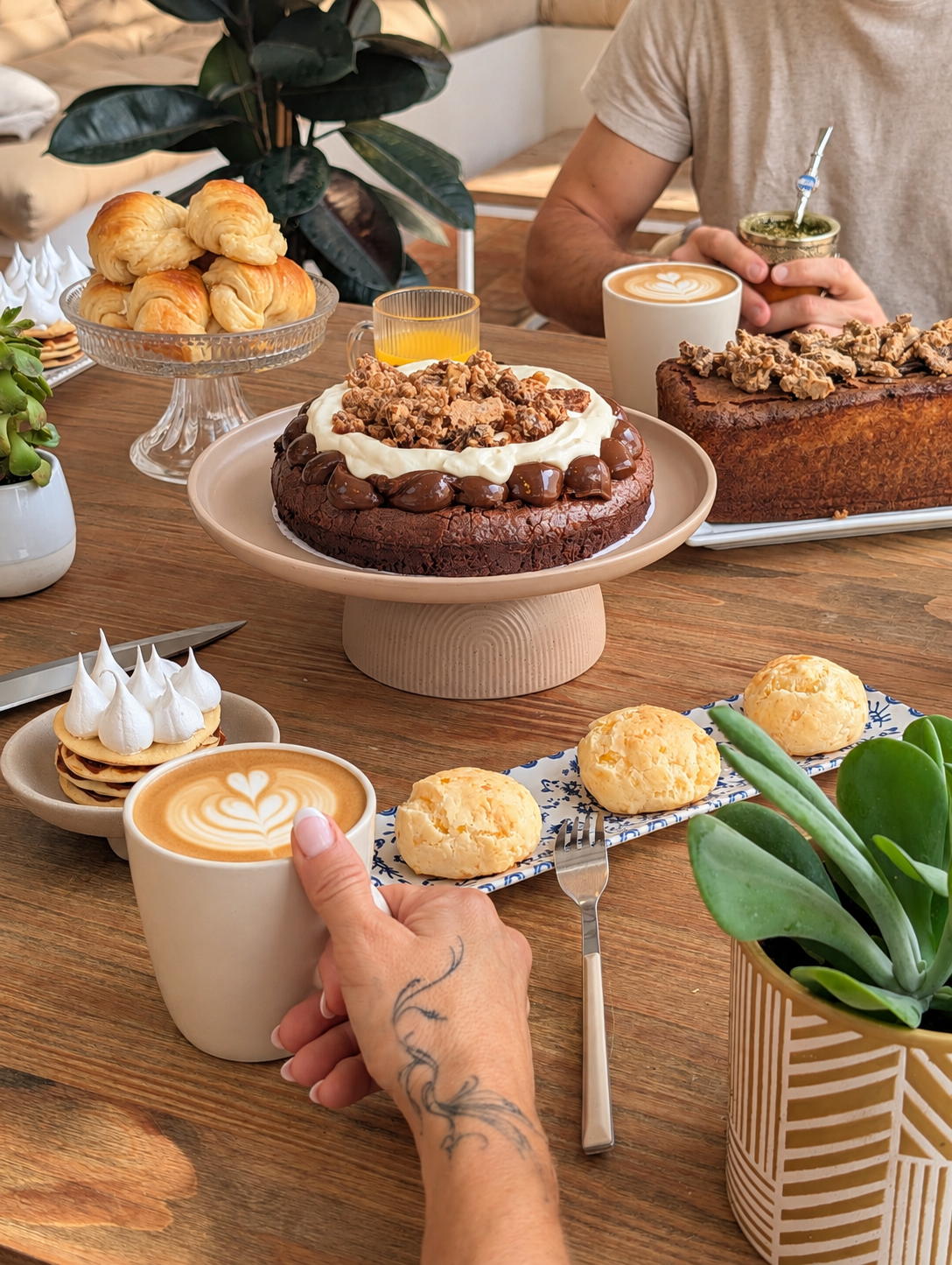 Mesa con pastelería, medialunas, café y mate compartidos